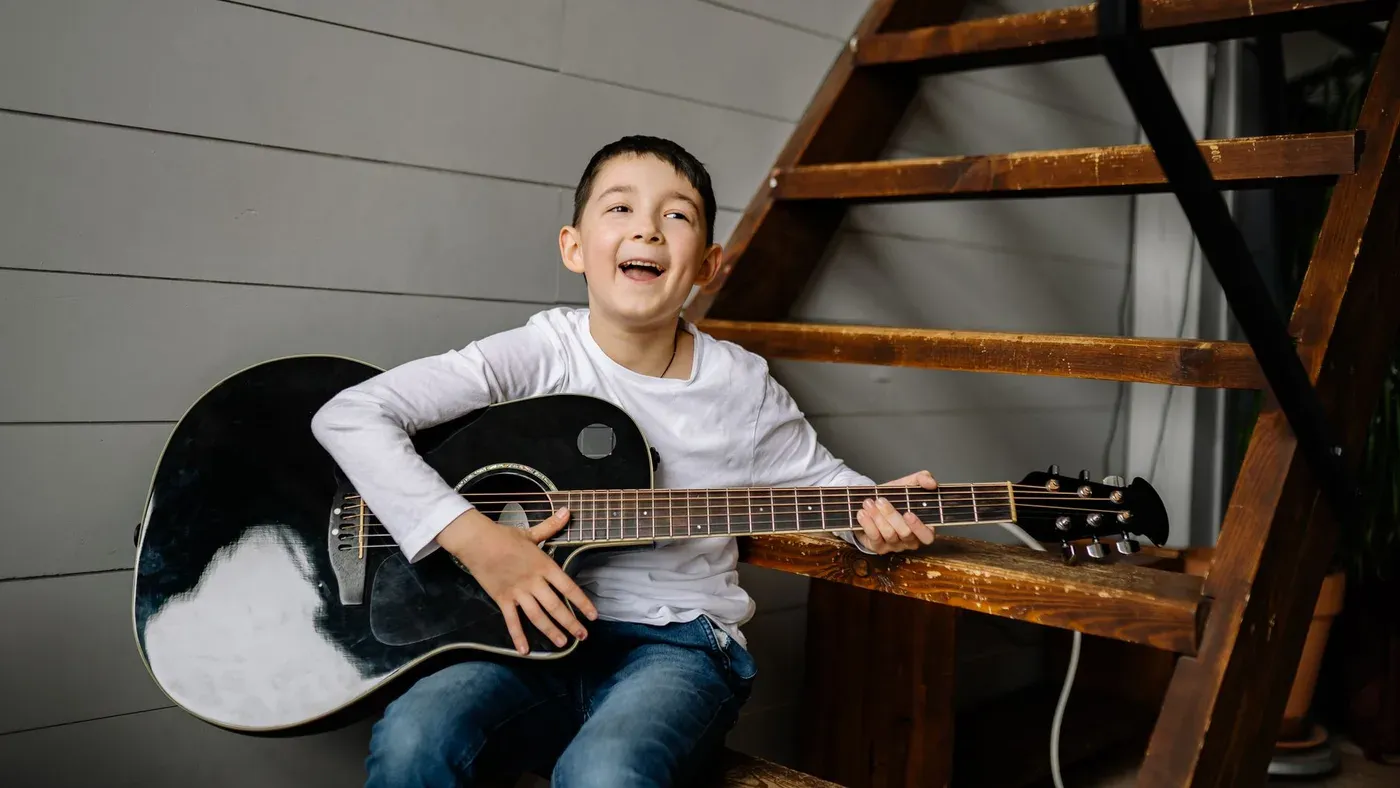 Barn som sjunger och spelar gitarr