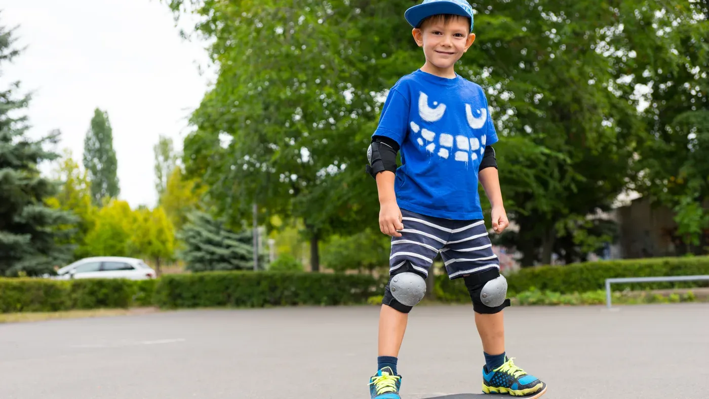 Barn i keps som leker i parken