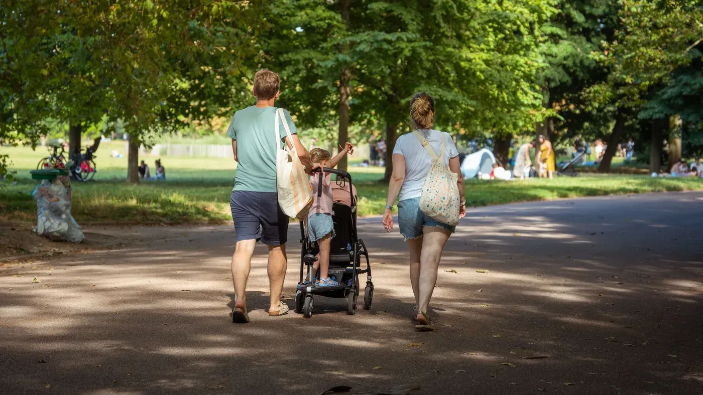 Familjer som promenerar med vagnar i en park