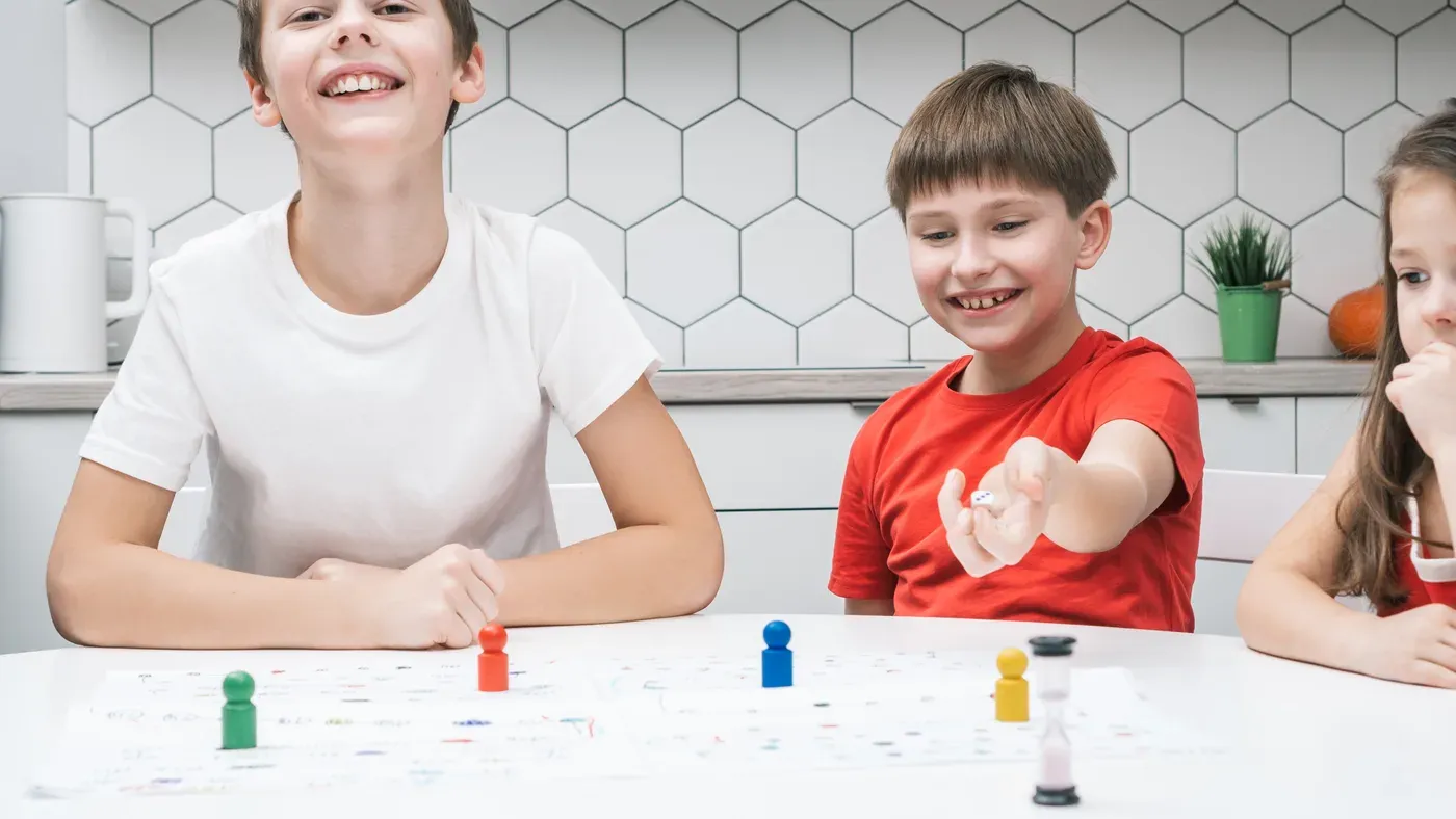 Barn som spelar ett sällskapsspel vid ett bord